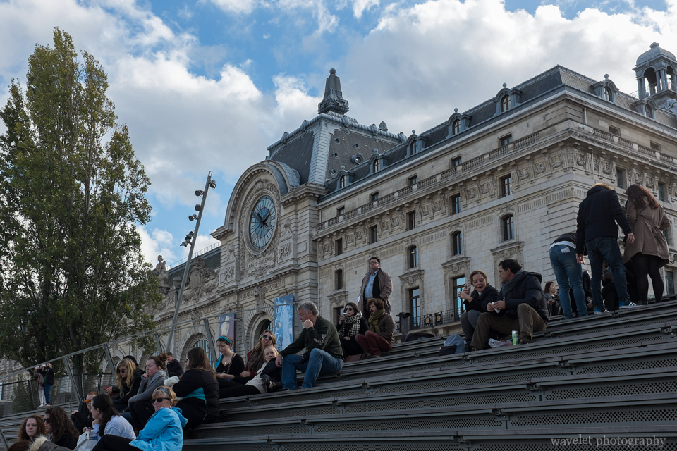 People sitting on the stairs by the River Seine outside of Musée d'Orsay, Paris